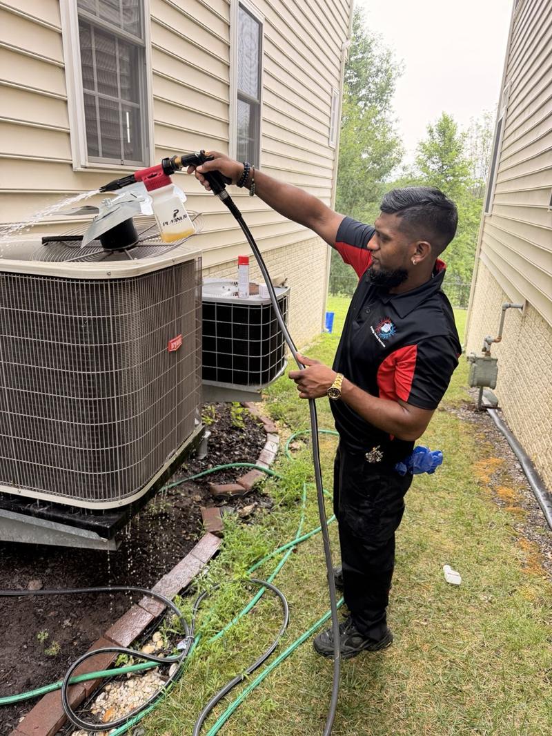 Josh cleaning an outdoor heat pump unit