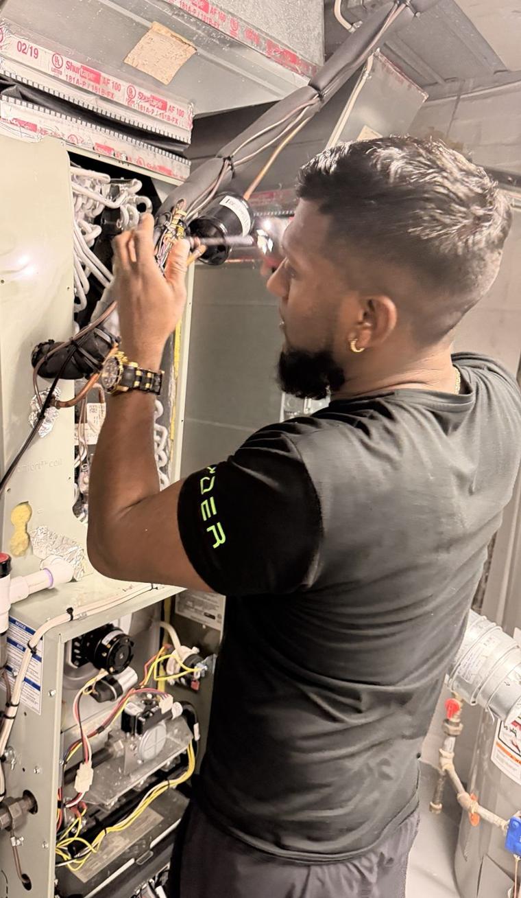 Josh testing the controls inside an open gas furnace